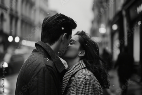 A monochrome snapshot of romance: A couple kisses tenderly on a snowy, city street, embodying love's warmth amidst the chill © Ai Studio