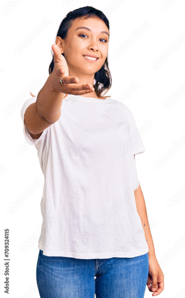 Young woman wearing casual clothes smiling friendly offering handshake as greeting and welcoming. successful business. Young woman wearing casual clothes smiling friendly offering handshake as greeting and welcoming. successful business.