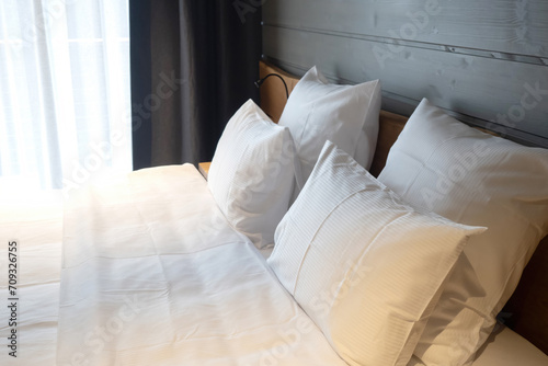 Double bed. Bedroom in hotel. Pillows with white sheets. Bed sheets. Bedroom interior. Bed with pillows close-up. Linens for comfortable sleep. Bunk for two people. Place to stay overnight