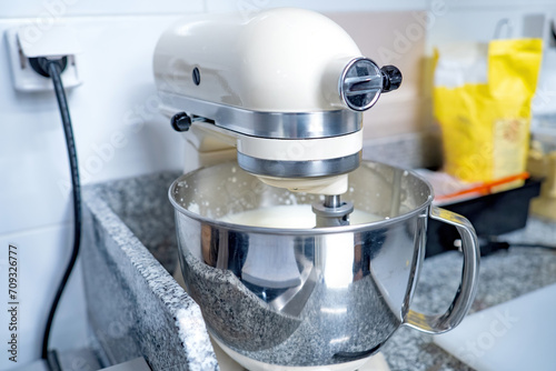 Mixer in restaurant kitchen. Equipment for preparing dough. Professional mixer stands on table. Restaurant kitchen equipment. Mixer beats sauce. Confectionery devices. Catering technology