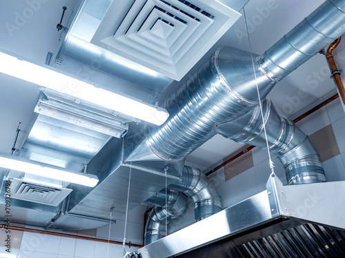 Restaurant ventilation system. Galvanized pipes with hoods. Ventilation ducts under ceiling. Air purification in confectionery shop. Ventilation of catering establishments. Restaurant equipment