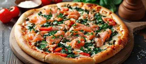 Stone-baked pizza with smoked salmon, spinach, capers, tomatoes, and cream cheese.