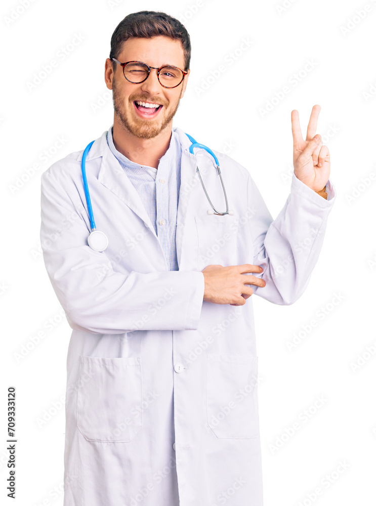 Handsome young man with bear wearing doctor uniform smiling with happy face winking at the camera doing victory sign. number two. Handsome young man with bear wearing doctor uniform smiling with happy face winking at the camera doing victory sign. number two.