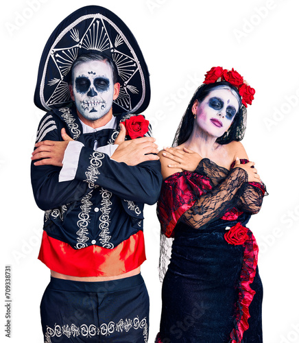 Young couple wearing mexican day of the dead costume over background hugging oneself happy and positive  smiling confident. self love and self care