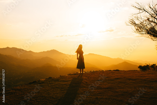 Silhouetted woman enjoying sunset over mountains in Minca, Colombia photo