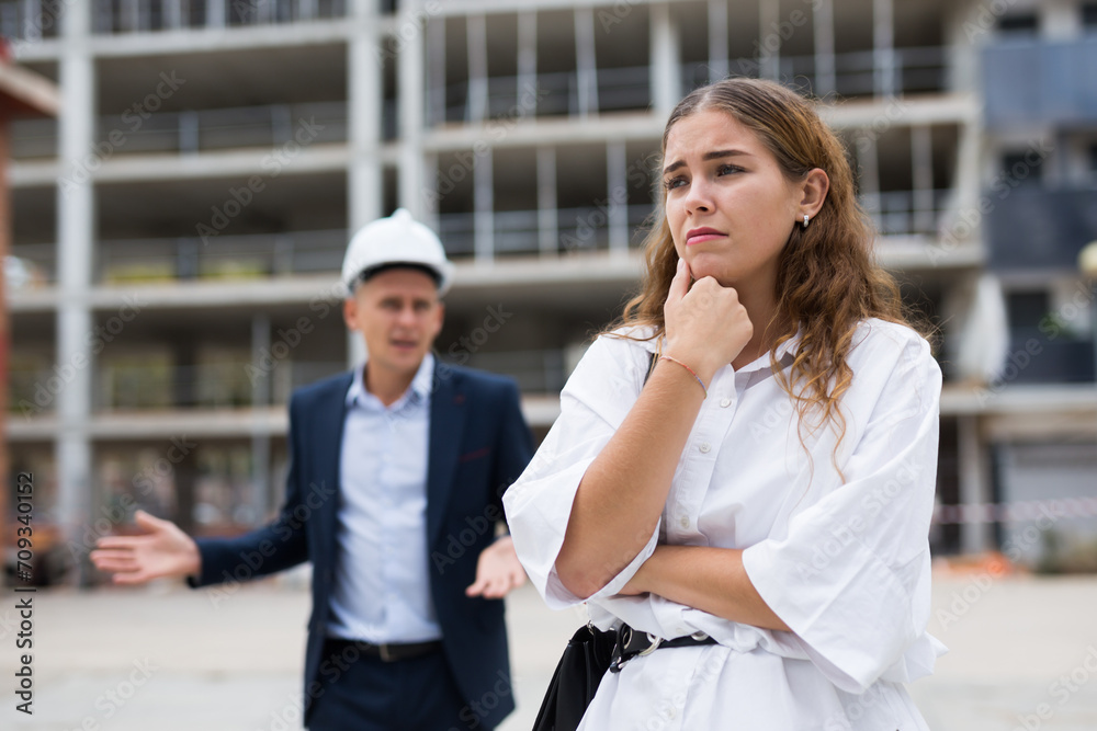 Fototapeta premium Portrait of a frustrated young woman who had a misunderstanding with a man contractor about cooperation