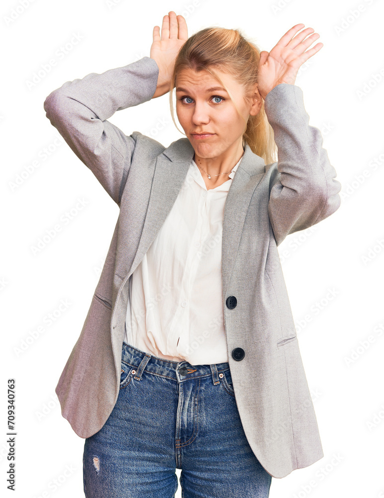 Young beautiful blonde woman wearing elegant jacket doing bunny ears gesture with hands palms looking cynical and skeptical. easter rabbit concept. Young beautiful blonde woman wearing elegant jacket doing bunny ears gesture with hands palms looking cynical and skeptical. easter rabbit concept.