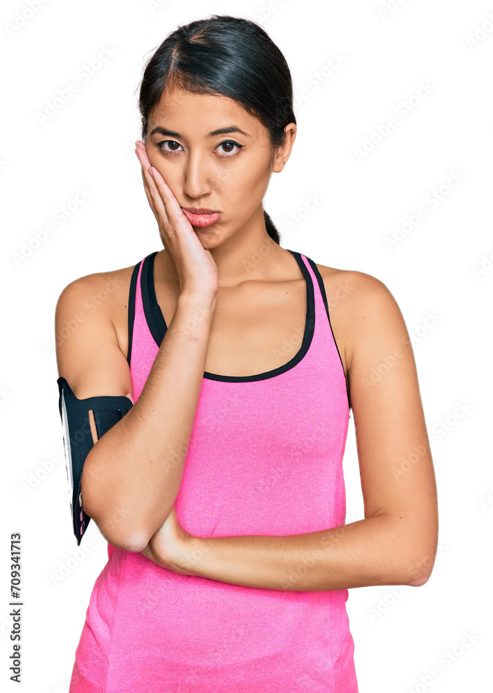 Beautiful asian young sport woman wearing sportswear and arm band thinking looking tired and bored with depression problems with crossed arms. Beautiful asian young sport woman wearing sportswear and arm band thinking looking tired and bored with depression problems with crossed arms.