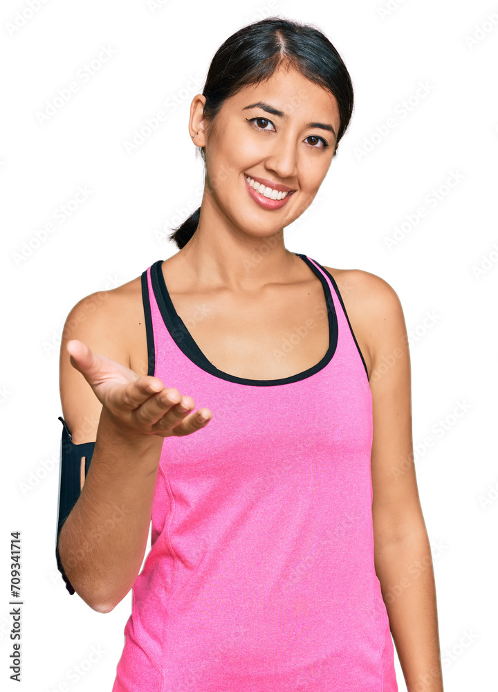 Beautiful asian young sport woman wearing sportswear and arm band smiling friendly offering handshake as greeting and welcoming. successful business. Beautiful asian young sport woman wearing sportswear and arm band smiling friendly offering handshake as greeting and welcoming. successful business.