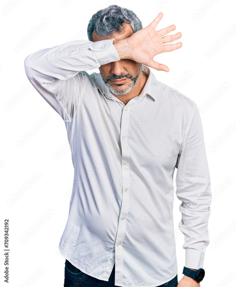 Middle age hispanic with grey hair wearing casual white shirt covering eyes with arm, looking serious and sad. sightless, hiding and rejection concept Middle age hispanic with grey hair wearing casual white shirt covering eyes with arm, looking serious and sad. sightless, hiding and rejection concept