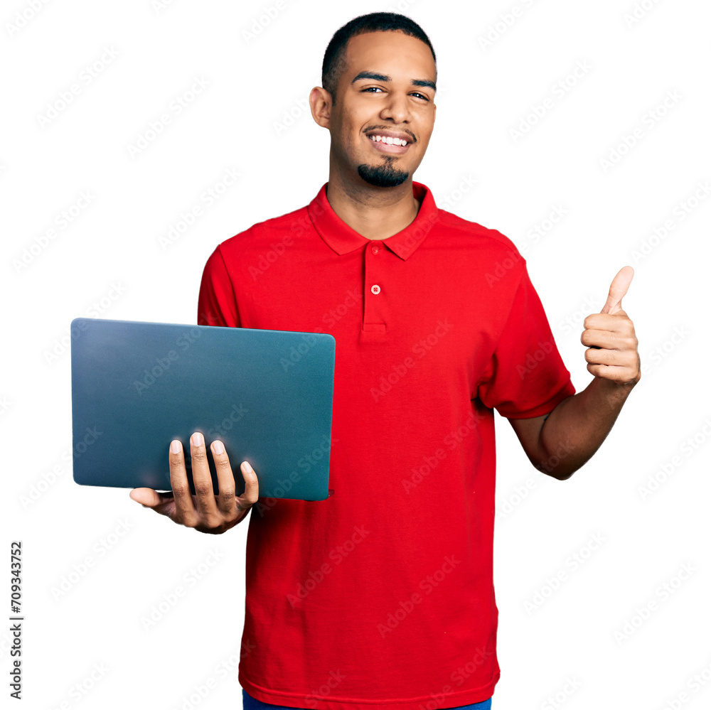 Young african american man working using computer laptop smiling happy and positive, thumb up doing excellent and approval sign Young african american man working using computer laptop smiling happy and positive, thumb up doing excellent and approval sign