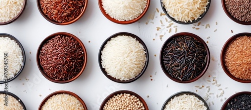 A variety of rice types displayed from above in bowls against a plain background. photo