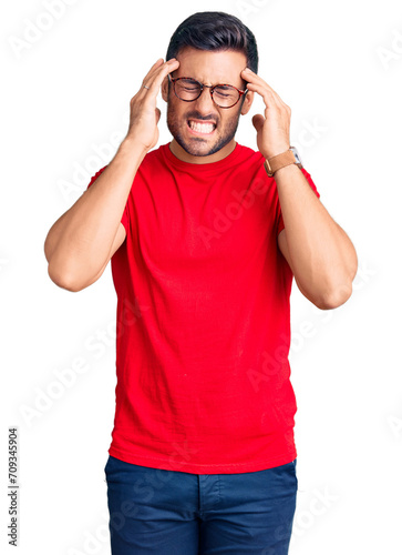 Young hispanic man wearing casual clothes and glasses suffering from headache desperate and stressed because pain and migraine. hands on head.