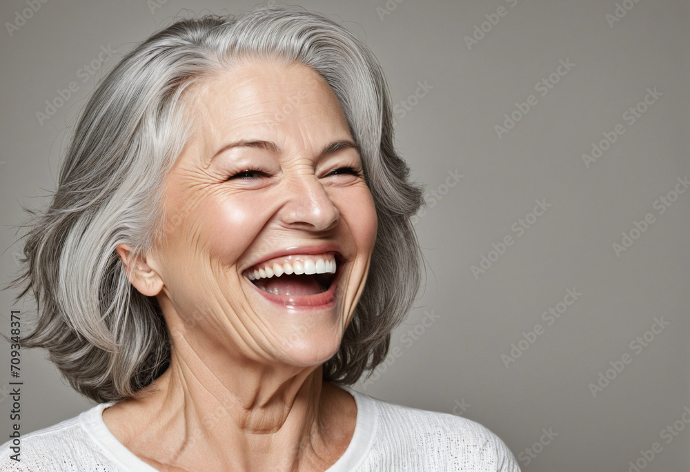 A Joyful Portrait of a Senior Model in Her 50s This close-up captures a mature woman with silvery hair, her smile showcasing health and happiness. The image reflects the glow of well-cared-for skin a A Joyful Portrait of a Senior Model in Her 50s This close-up captures a mature woman with silvery hair, her smile showcasing health and happiness. The image reflects the glow of well-cared-for skin a