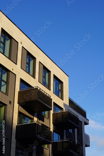 Close up of new building facade with balconies with sunlight. Kalamaja, Tallinn, Estonia, Europe. January 2024