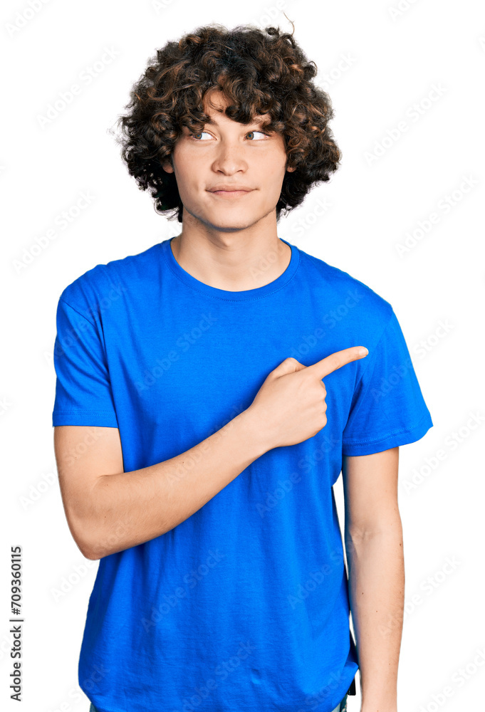 Caucasian teenager pointing with fingers to the side smiling looking to the side and staring away thinking. Caucasian teenager pointing with fingers to the side smiling looking to the side and staring away thinking.