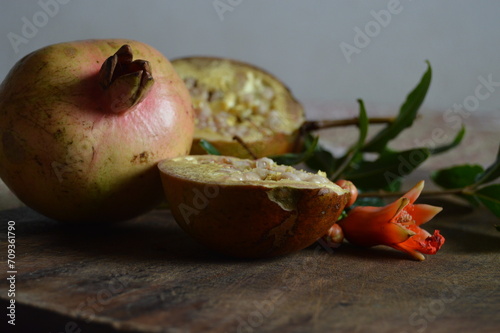 fresh pomegranate on rustic wooden board with copy space photo