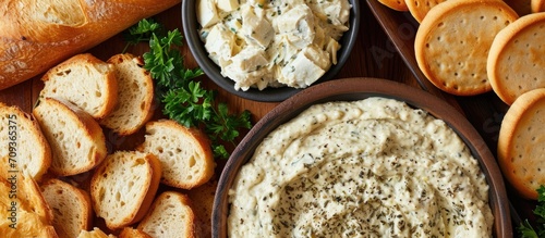 Artichoke dip with assorted breads and crackers for dipping, in a close-up view. photo