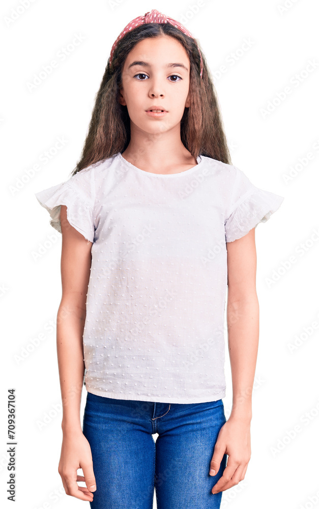 Obraz premium Cute hispanic child girl wearing casual white tshirt relaxed with serious expression on face. simple and natural looking at the camera.