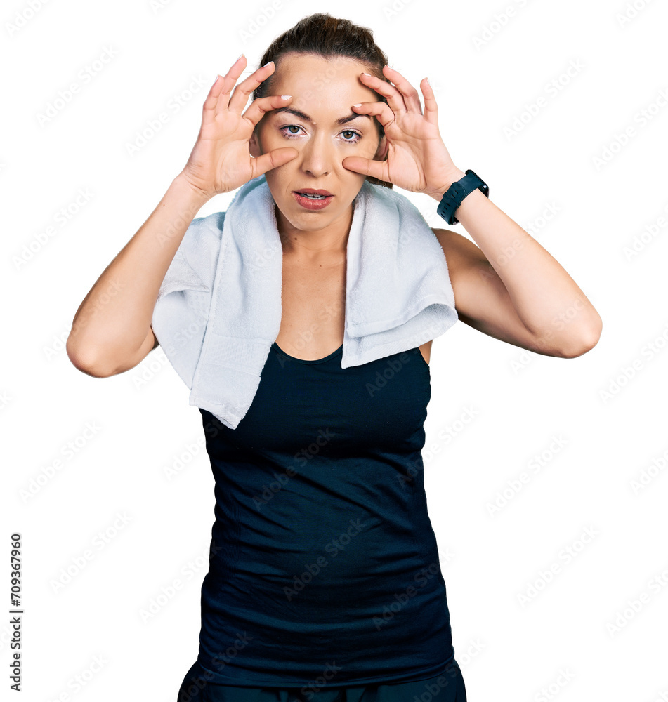 Young caucasian woman wearing sportswear and towel trying to open eyes with fingers, sleepy and tired for morning fatigue
