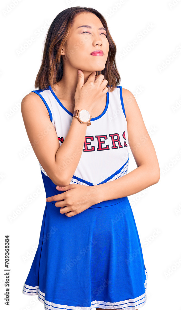Young beautiful chinese girl wearing cheerleader uniform touching painful neck, sore throat for flu, clod and infection Young beautiful chinese girl wearing cheerleader uniform touching painful neck, sore throat for flu, clod and infection