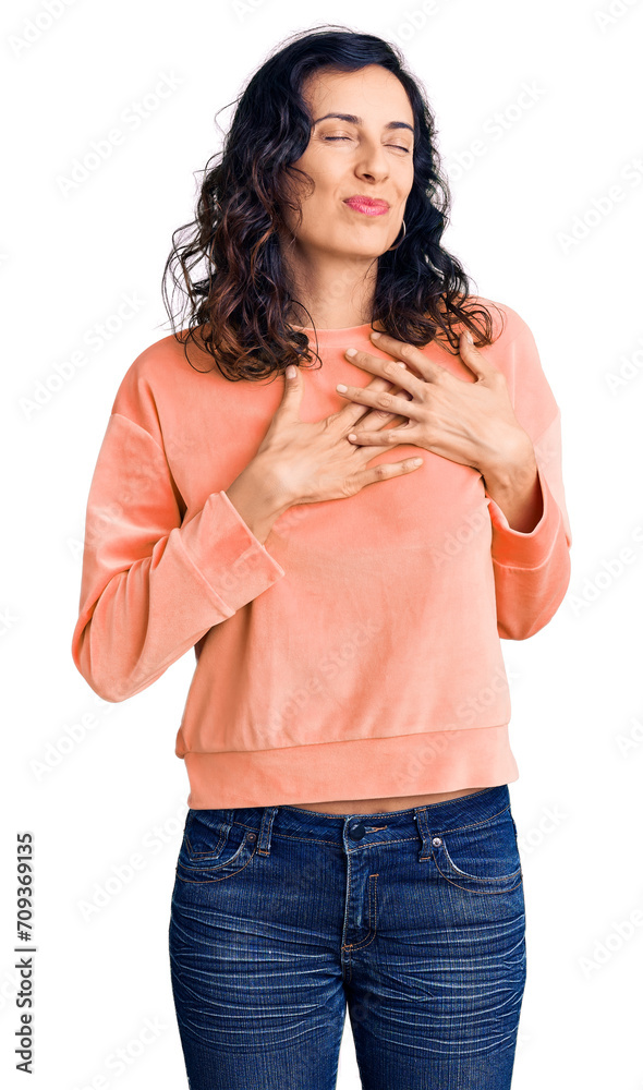 Young beautiful hispanic woman wearing casual clothes smiling with hands on chest with closed eyes and grateful gesture on face. health concept. Young beautiful hispanic woman wearing casual clothes smiling with hands on chest with closed eyes and grateful gesture on face. health concept.