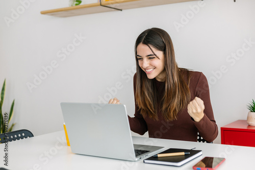 фотографія Excited young adult businesswoman feeling happy after receiving good news on email
