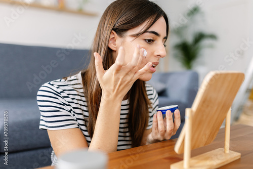 Young pretty woman applying skin cream at her face. Female diary routine lifestyle concept. Free Download Young pretty woman applying skin cream at her face. Female diary routine lifestyle concept. - GFXLoad