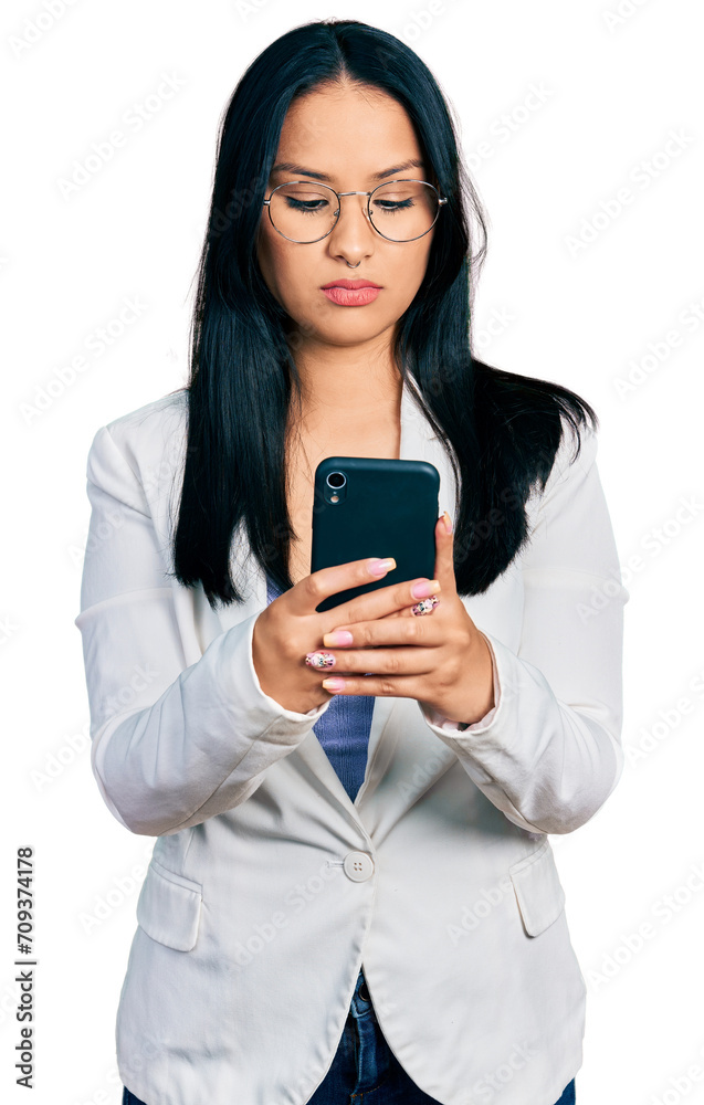 Beautiful hispanic woman with nose piercing using smartphone typing message relaxed with serious expression on face. simple and natural looking at the camera.