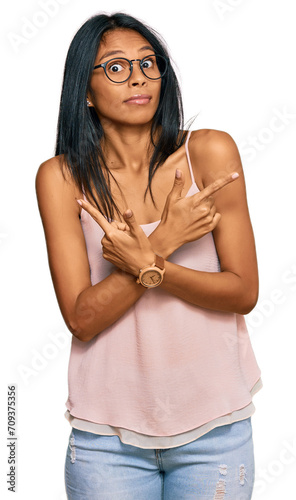 Young african american woman wearing casual clothes and glasses pointing to both sides with fingers, different direction disagree © Krakenimages.com