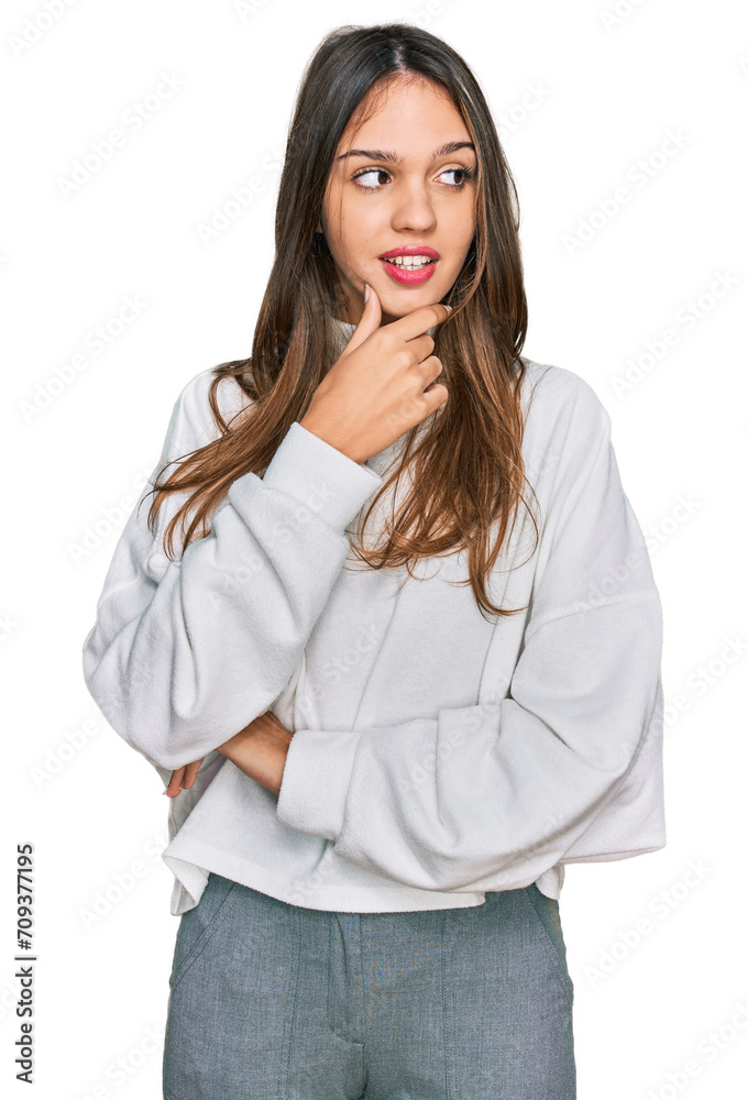 Young brunette woman wearing casual turtleneck sweater with hand on chin thinking about question, pensive expression. smiling with thoughtful face. doubt concept. Young brunette woman wearing casual turtleneck sweater with hand on chin thinking about question, pensive expression. smiling with thoughtful face. doubt concept.