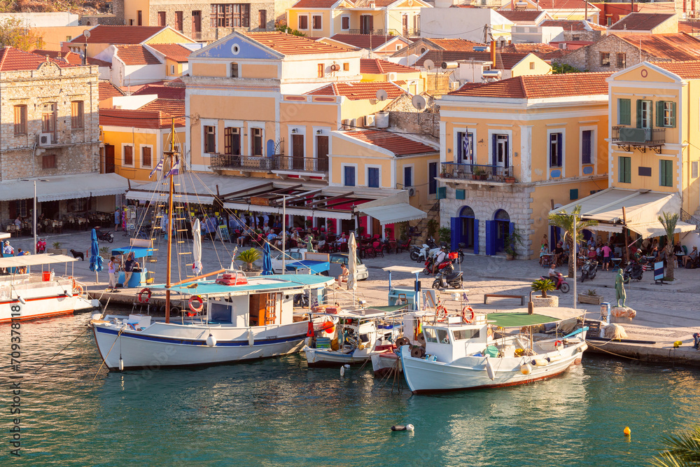 Multi-colored facades of houses in the village of Symi at sunset.