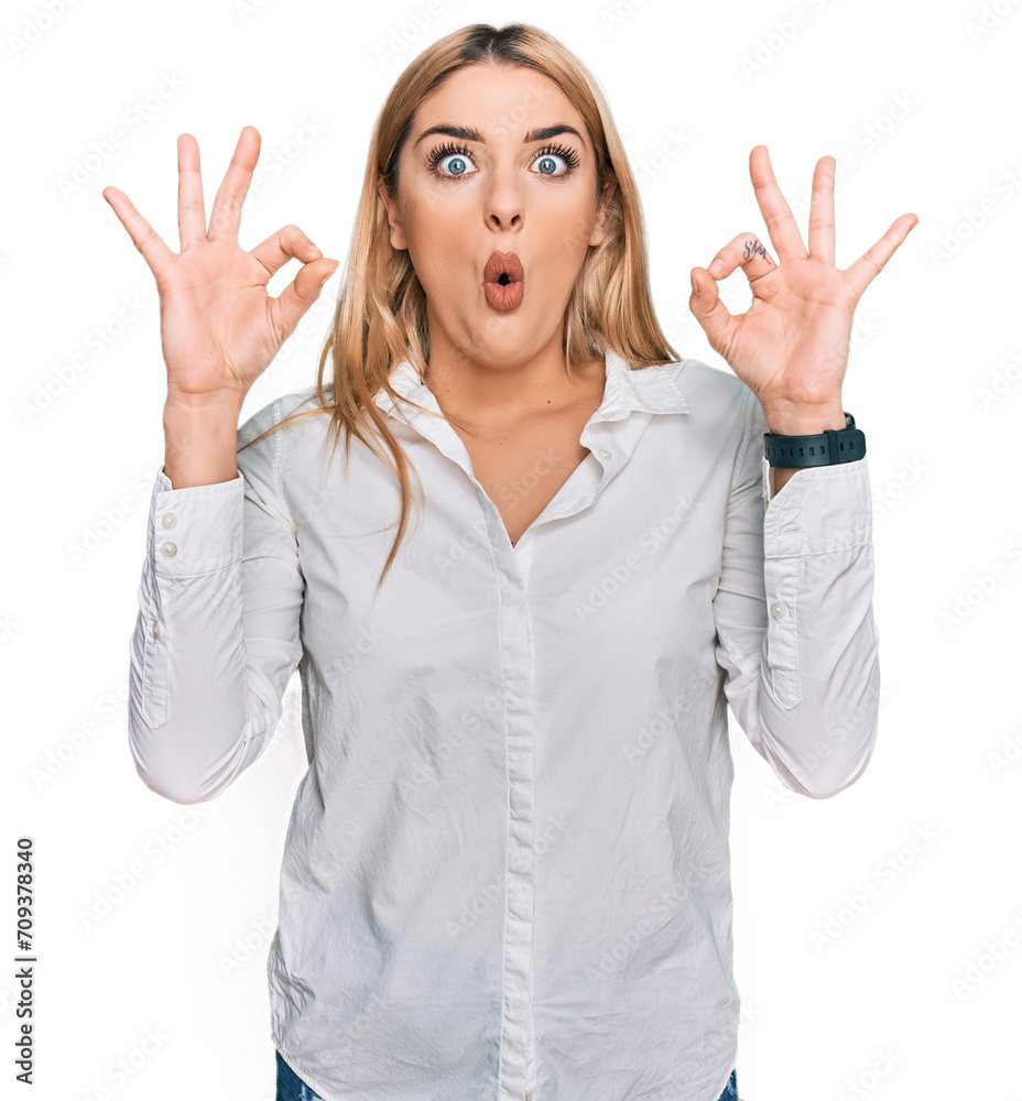 Young caucasian woman wearing casual clothes looking surprised and shocked doing ok approval symbol with fingers. crazy expression Young caucasian woman wearing casual clothes looking surprised and shocked doing ok approval symbol with fingers. crazy expression