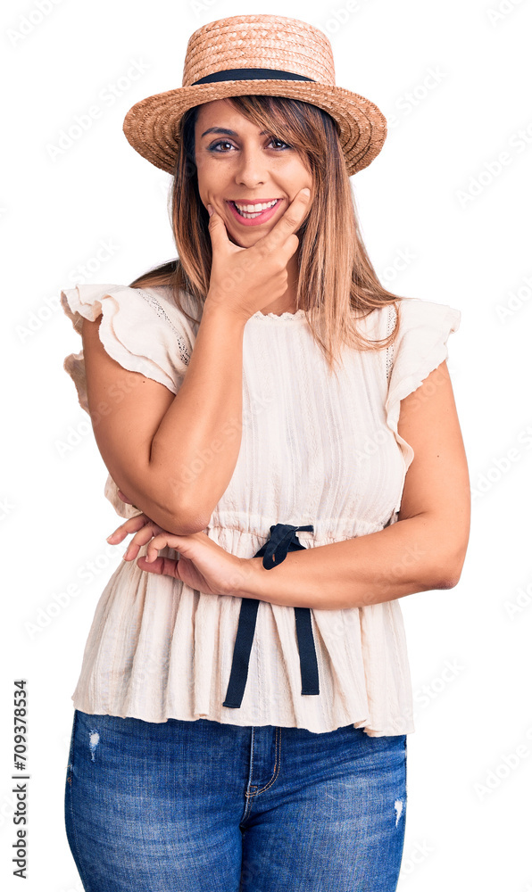 Young beautiful woman wearing summer hat and t-shirt looking confident at the camera smiling with crossed arms and hand raised on chin. thinking positive. Young beautiful woman wearing summer hat and t-shirt looking confident at the camera smiling with crossed arms and hand raised on chin. thinking positive.