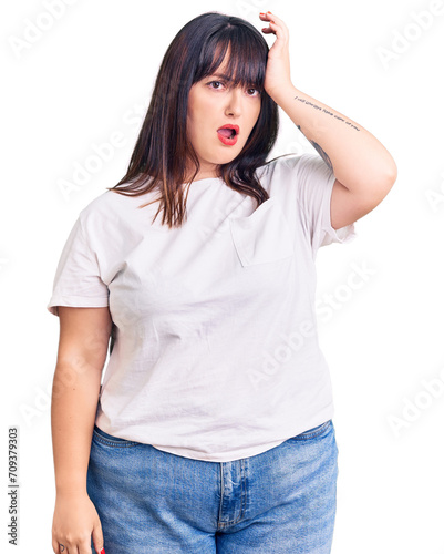 Young plus size woman wearing casual clothes surprised with hand on head for mistake, remember error. forgot, bad memory concept.