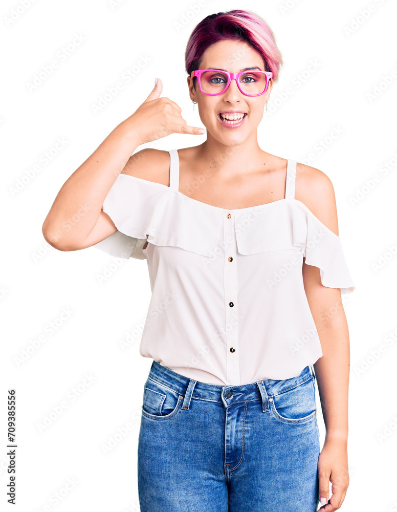 Young beautiful woman with pink hair wearing casual clothes and glasses smiling doing phone gesture with hand and fingers like talking on the telephone. communicating concepts. Young beautiful woman with pink hair wearing casual clothes and glasses smiling doing phone gesture with hand and fingers like talking on the telephone. communicating concepts.