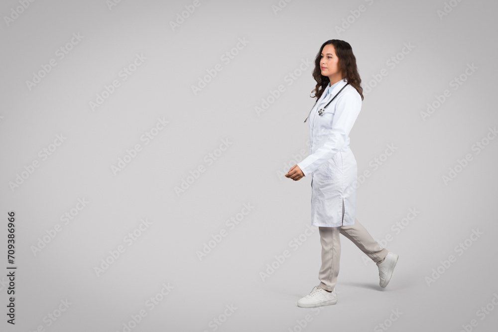 Female doctor walking confidently in white coat, free space Female doctor walking confidently in white coat, free space