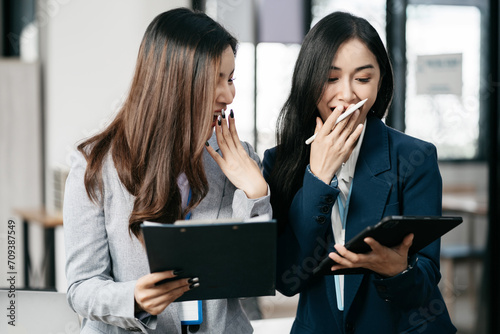 Asian business woman are excited business success with inspiration from their excellent financial results that are happy working in a modern office on a computer.