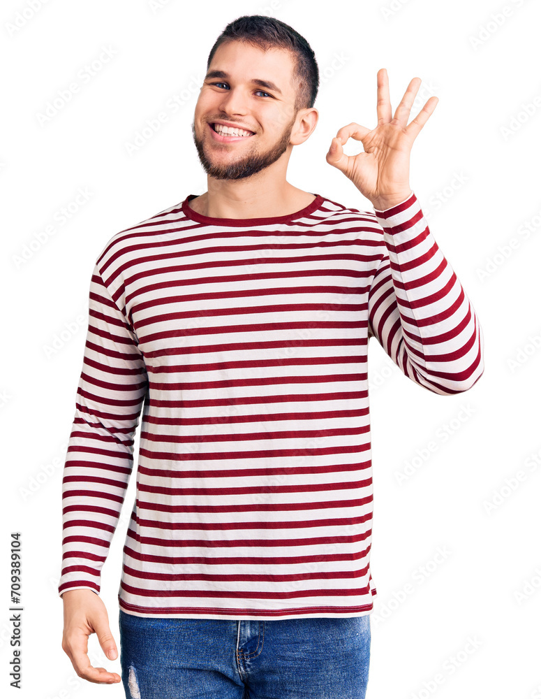 Young handsome man wearing striped sweater smiling positive doing ok sign with hand and fingers. successful expression. Young handsome man wearing striped sweater smiling positive doing ok sign with hand and fingers. successful expression.