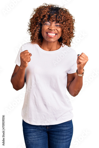 Young african american woman wearing casual white tshirt excited for success with arms raised and eyes closed celebrating victory smiling. winner concept.