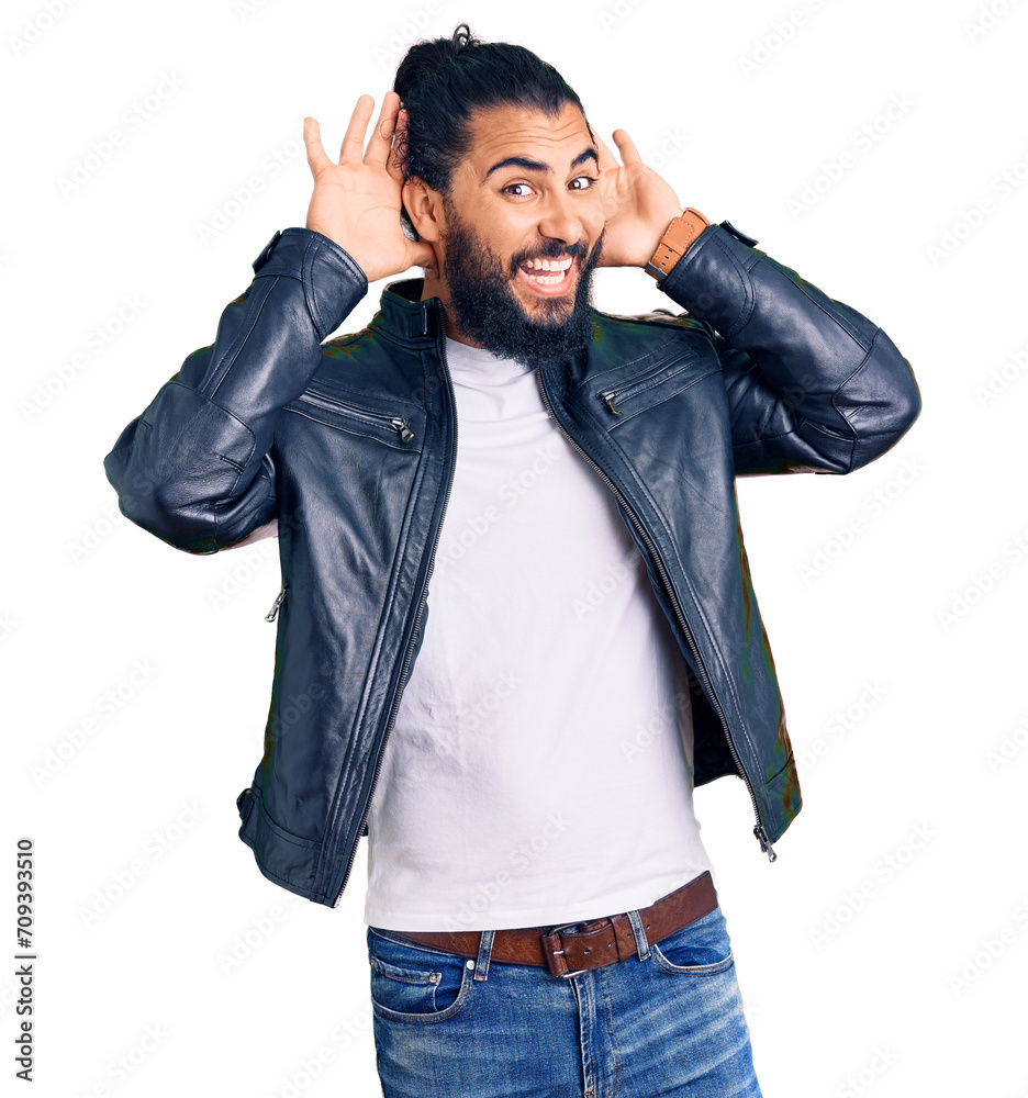 Young arab man wearing casual leather jacket smiling cheerful playing peek a boo with hands showing face. surprised and exited Young arab man wearing casual leather jacket smiling cheerful playing peek a boo with hands showing face. surprised and exited