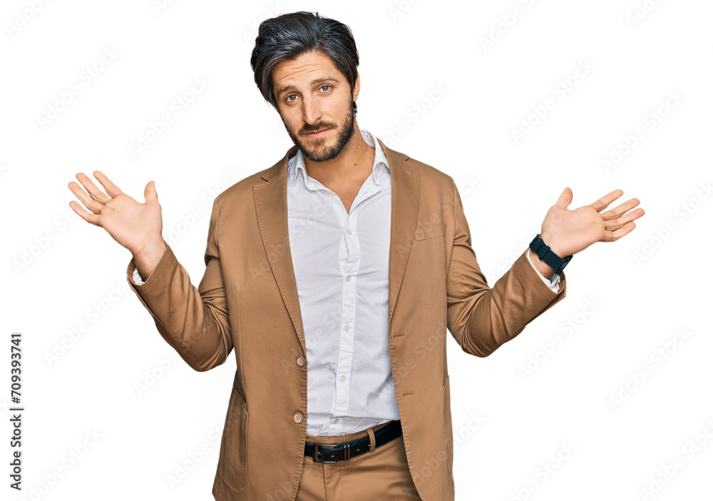 Young hispanic man wearing business clothes clueless and confused expression with arms and hands raised. doubt concept. Young hispanic man wearing business clothes clueless and confused expression with arms and hands raised. doubt concept.