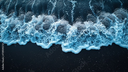 Crystal clear blue ocean waves on a black beach. Colorful contrasting surf