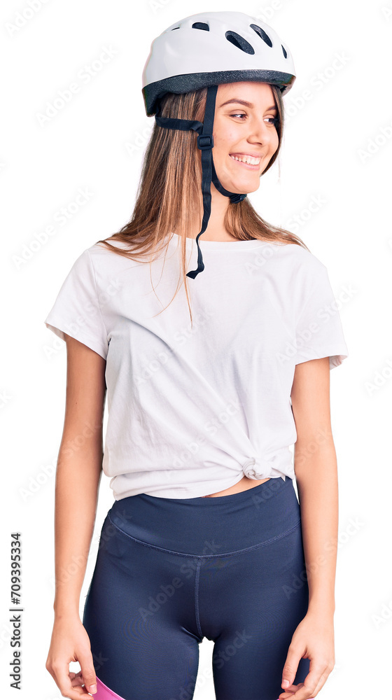 Young beautiful girl wearing bike helmet looking away to side with smile on face, natural expression. laughing confident. Young beautiful girl wearing bike helmet looking away to side with smile on face, natural expression. laughing confident.