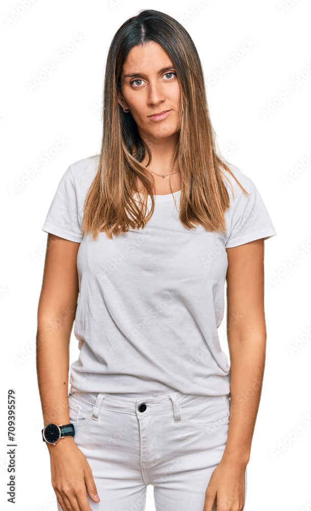 Young woman wearing casual white t shirt with serious expression on face. simple and natural looking at the camera. Young woman wearing casual white t shirt with serious expression on face. simple and natural looking at the camera.