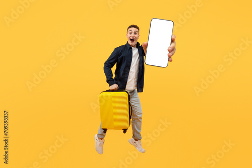 Tourism and holiday trip concept, guy showing phone, holding suitcase photo
