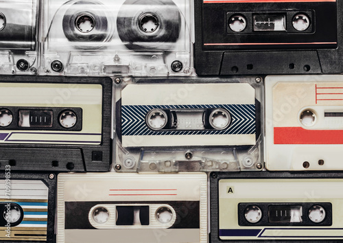 Photo of pile of old retro audio tape cassettes laying on flat surface.