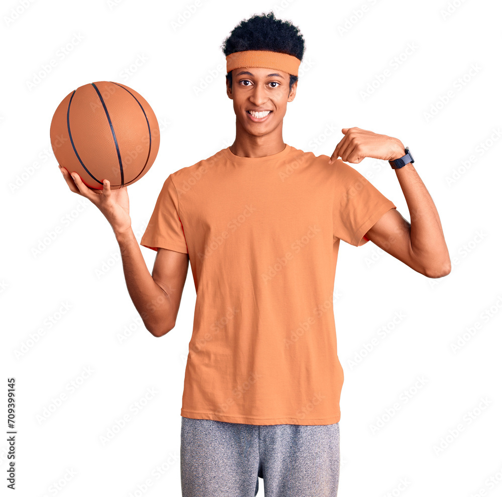 Young african american man holding basketball ball pointing finger to one self smiling happy and proud