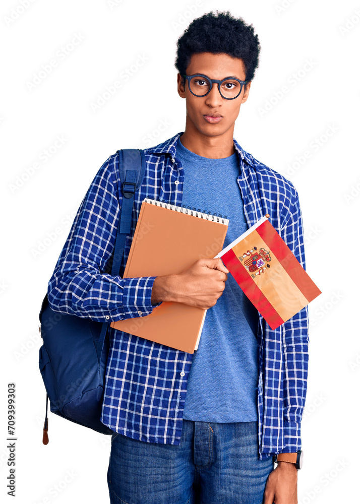 Young african american man wearing student backpack holding spanish flag thinking attitude and sober expression looking self confident Young african american man wearing student backpack holding spanish flag thinking attitude and sober expression looking self confident