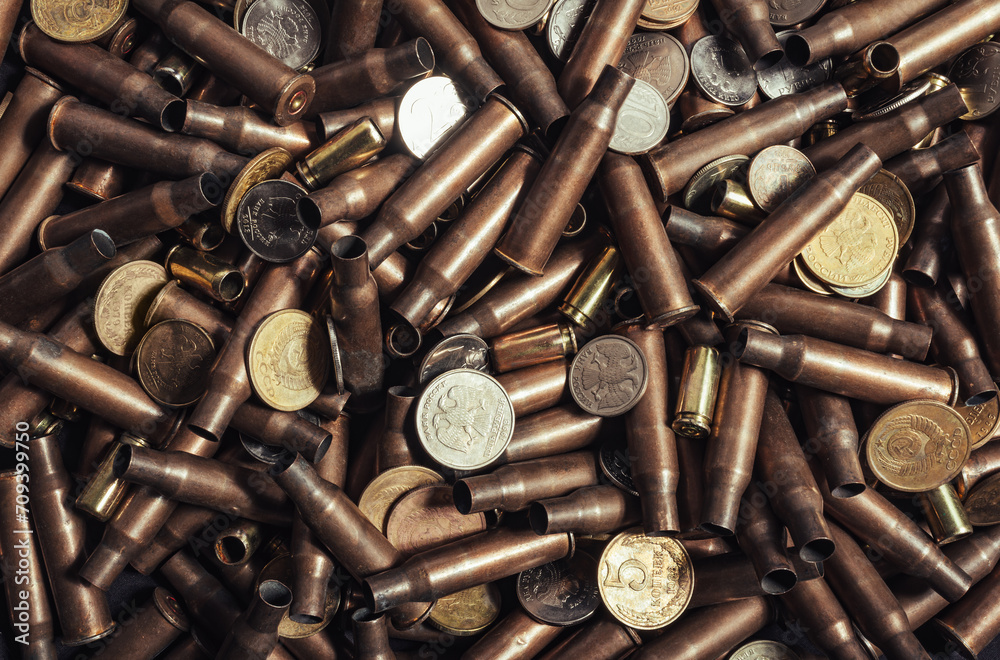 Photo of Russian coins laying on empty AK rifle bullet shells. Photo of Russian coins laying on empty AK rifle bullet shells.
